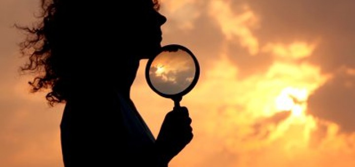 stock-footage-woman-holds-magnifier-and-puts-it-to-chin-against-sky-and-sun-720x340.jpg